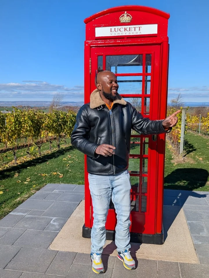 A parent abroad, standing by a red telephone box, after paying school fees from overseas.